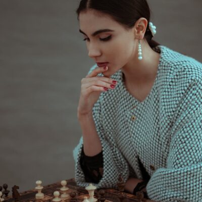 focused woman thinking about next move and playing chess