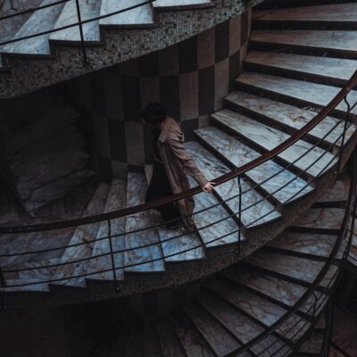 woman walking down swirling staircase