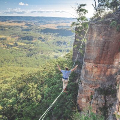 man walking on string over the hill during daytime