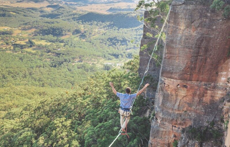 man walking on string over the hill during daytime