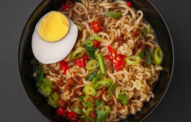 noodles with sliced lemon on black ceramic bowl