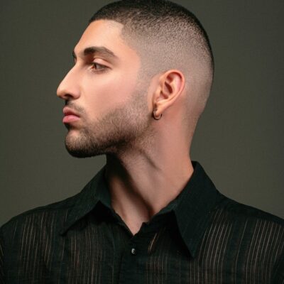 a man with a shaved head and a black shirt