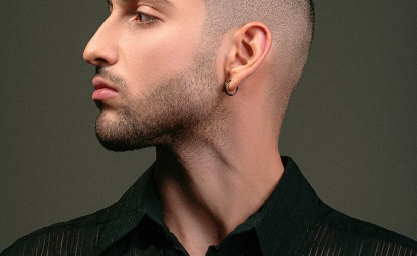 a man with a shaved head and a black shirt