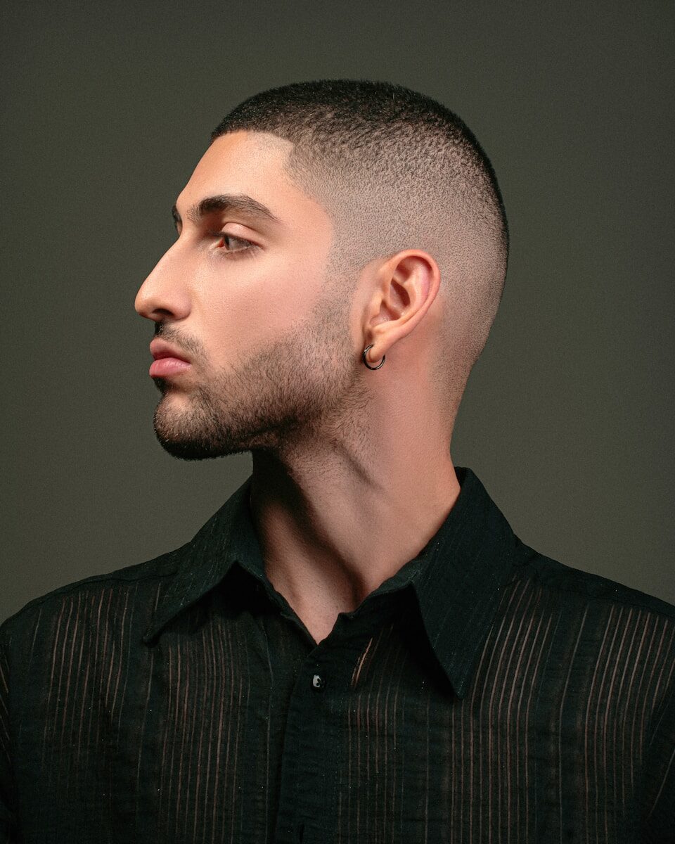 a man with a shaved head and a black shirt